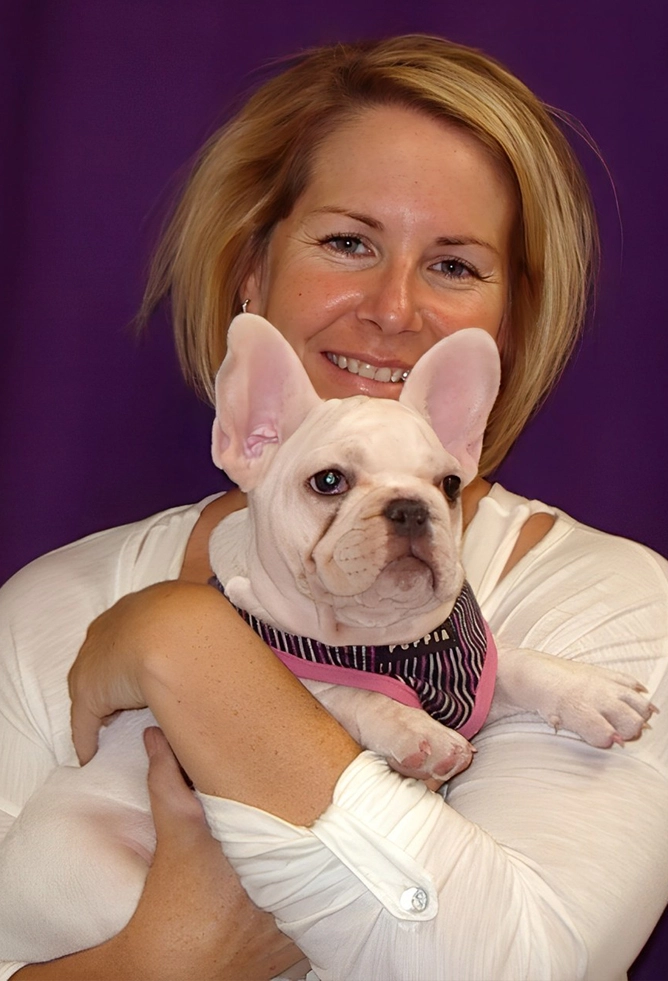 A woman gently holds a white and brown dog